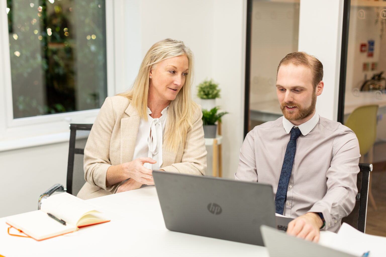 Two staff members looking at a computer.