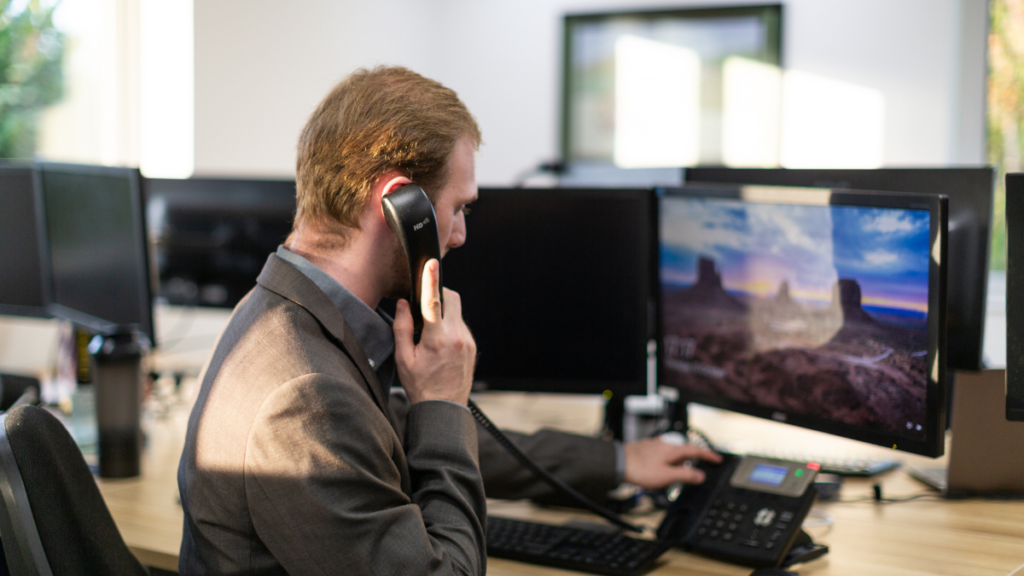 Resolve IT support on the phone with computers in the background