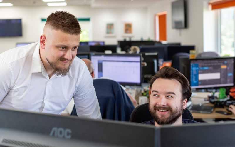 Two team members looking at a computer together