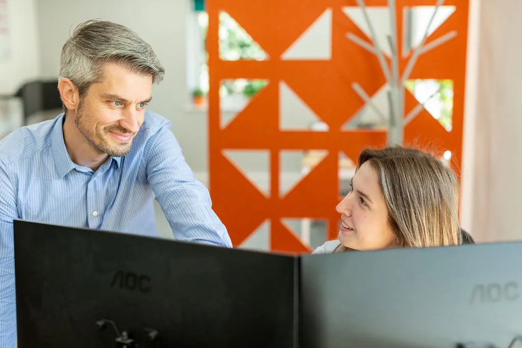 Two people in front of computer.