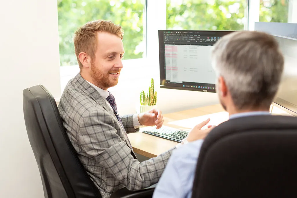 Two people by a computer.